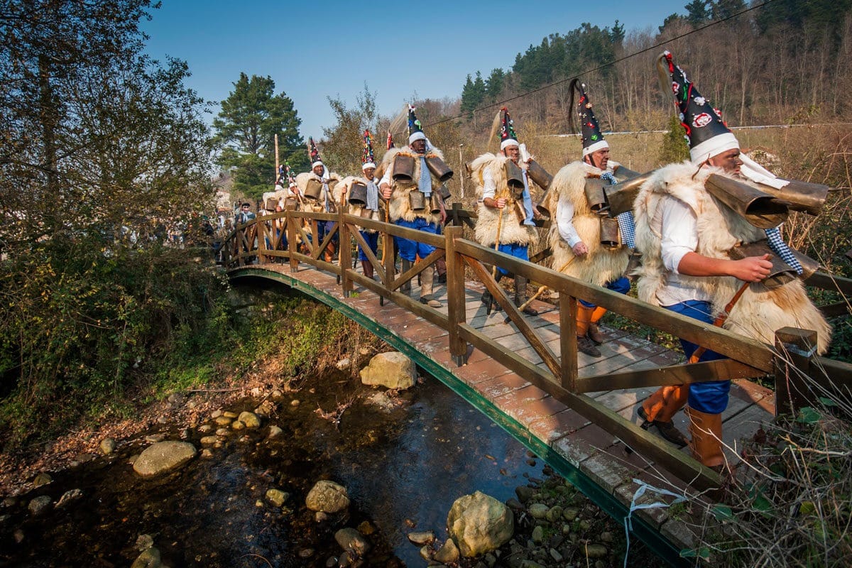 Zarramacos con pieles y cencerros desfilando por Silió durante la Vijanera