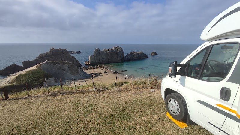 Aparcamiento no vigilado en el prado junto a la playa de Covachos, a 500 metros de la arena