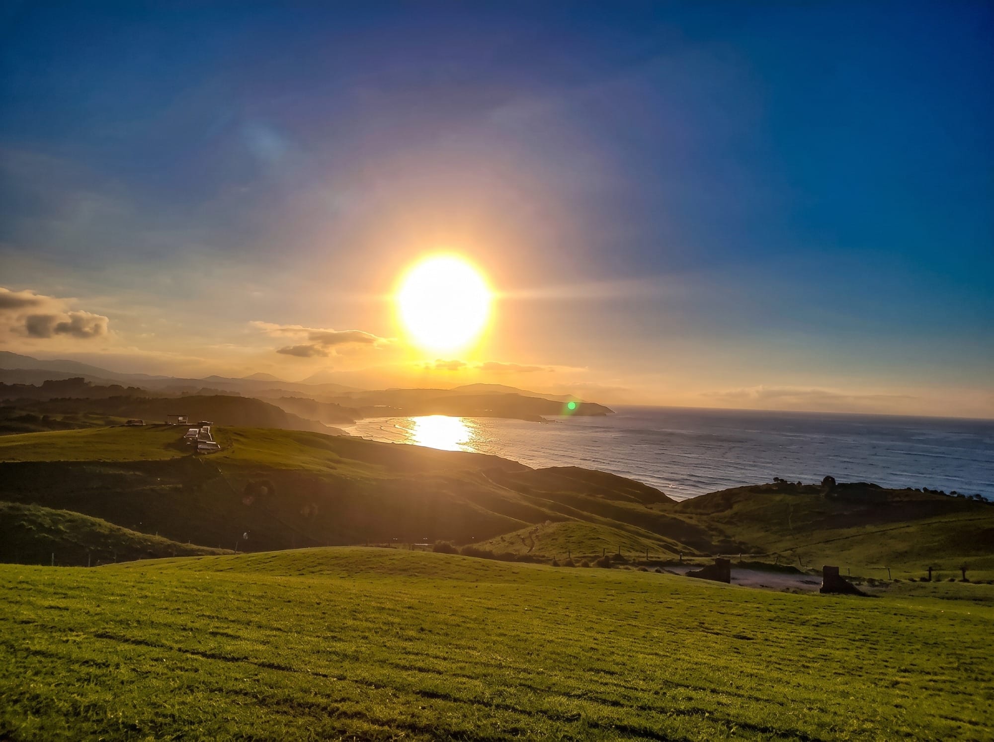 Costa cantábrica al atardecer de otoño con el sol bajo sobre el mar