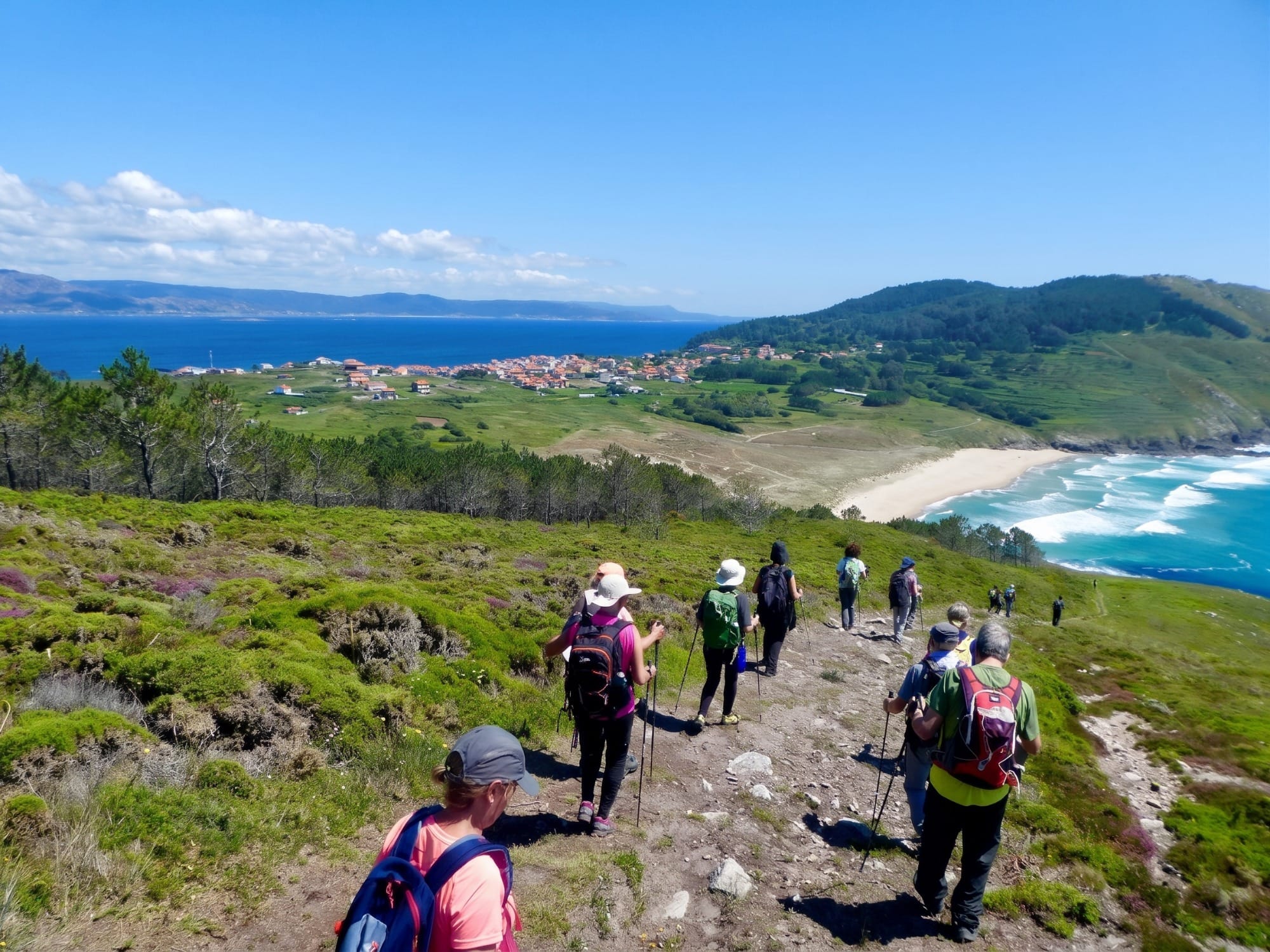 Senderistas en un camino de la costa de Trasmiera con luz baja de tarde