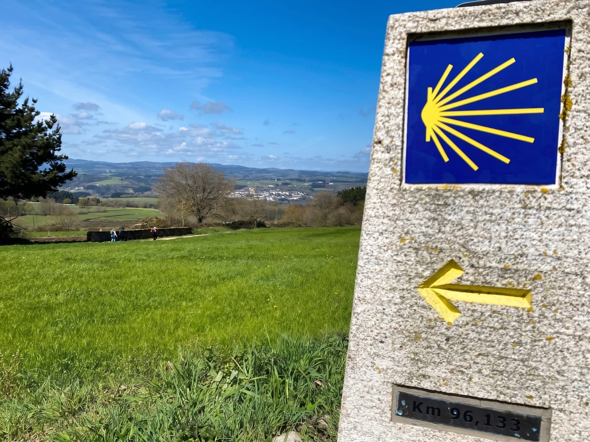 Señal o flecha amarilla del Camino de Santiago en la salida de Güemes, luz de mañana