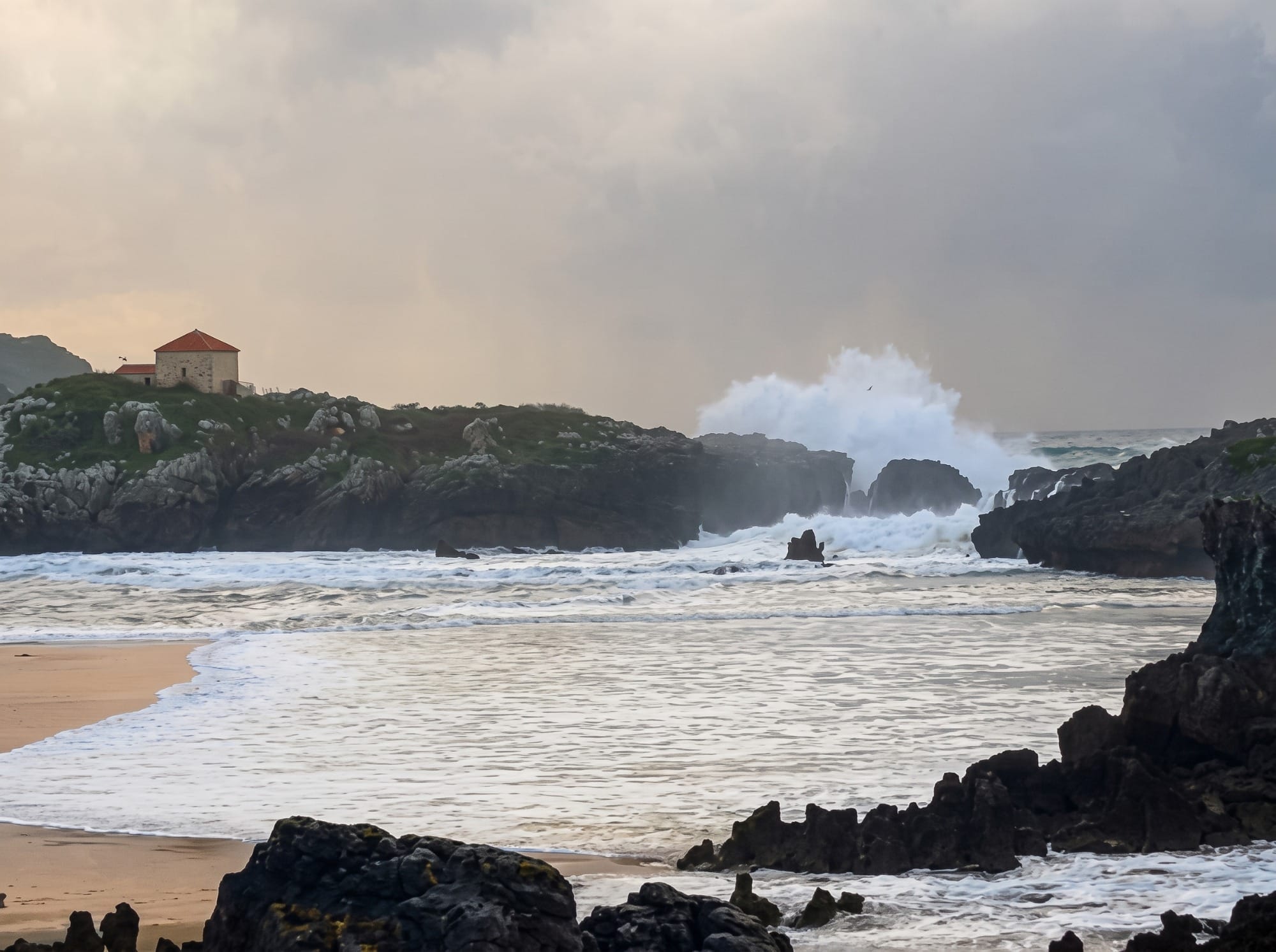 Mar picado y olas rompiendo en la orilla de una playa cantábrica con marejada de otoño