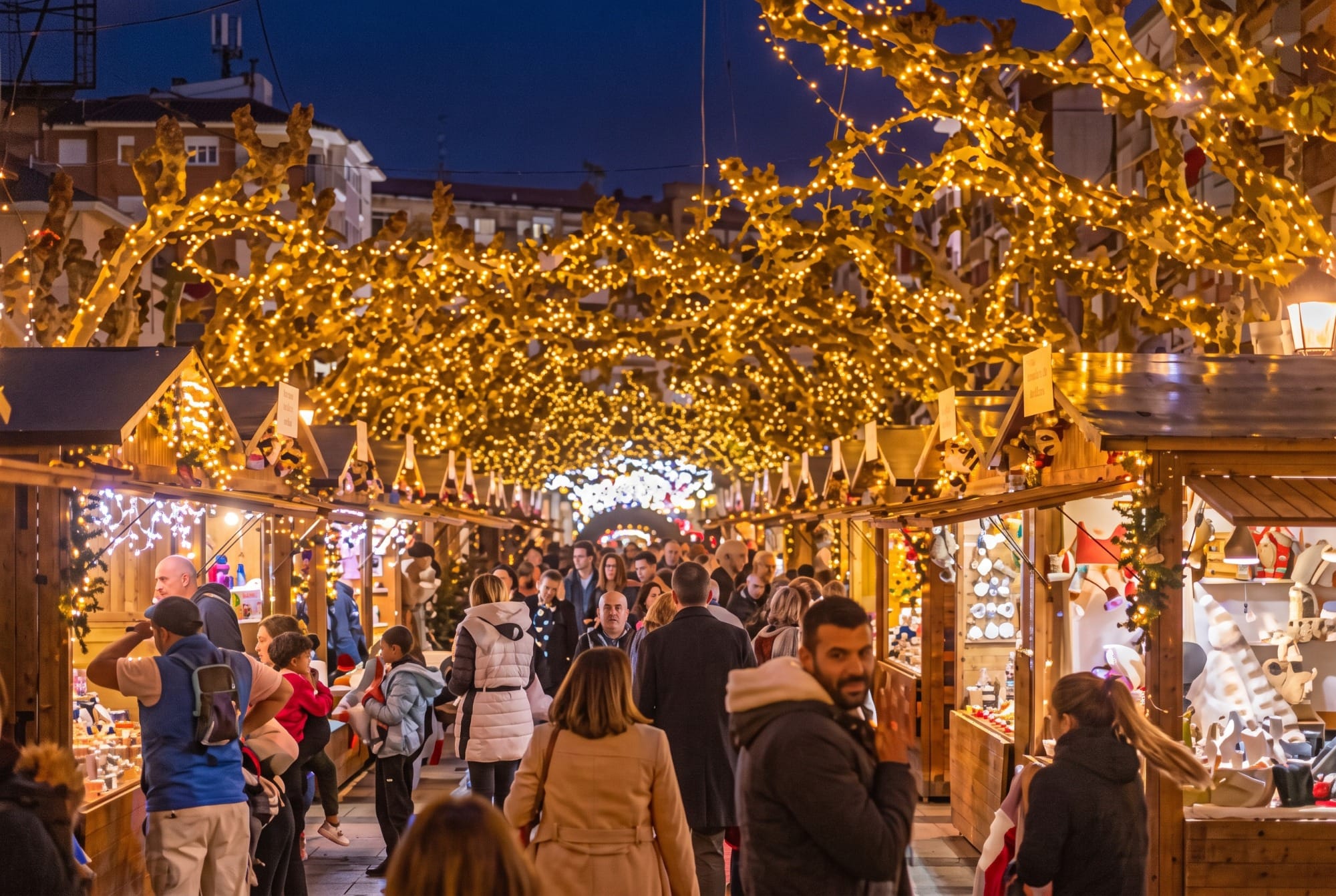 Weihnachtsmarkt mit Holzhütten auf einem Platz in Santander oder Noja, Abendstimmung