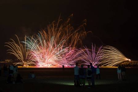 Feu d'artifice nocturne au-dessus de la plage de Salvé à Laredo, vu depuis la promenade maritime