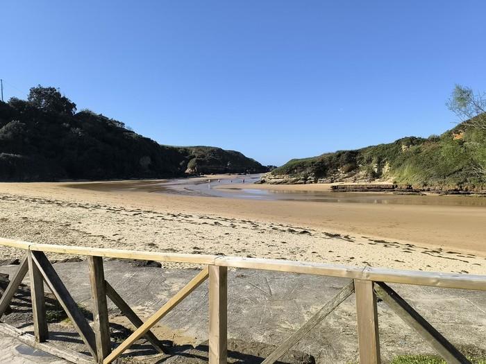 Strand von Galizano bei Flut unter bewölktem Himmel am späten Nachmittag