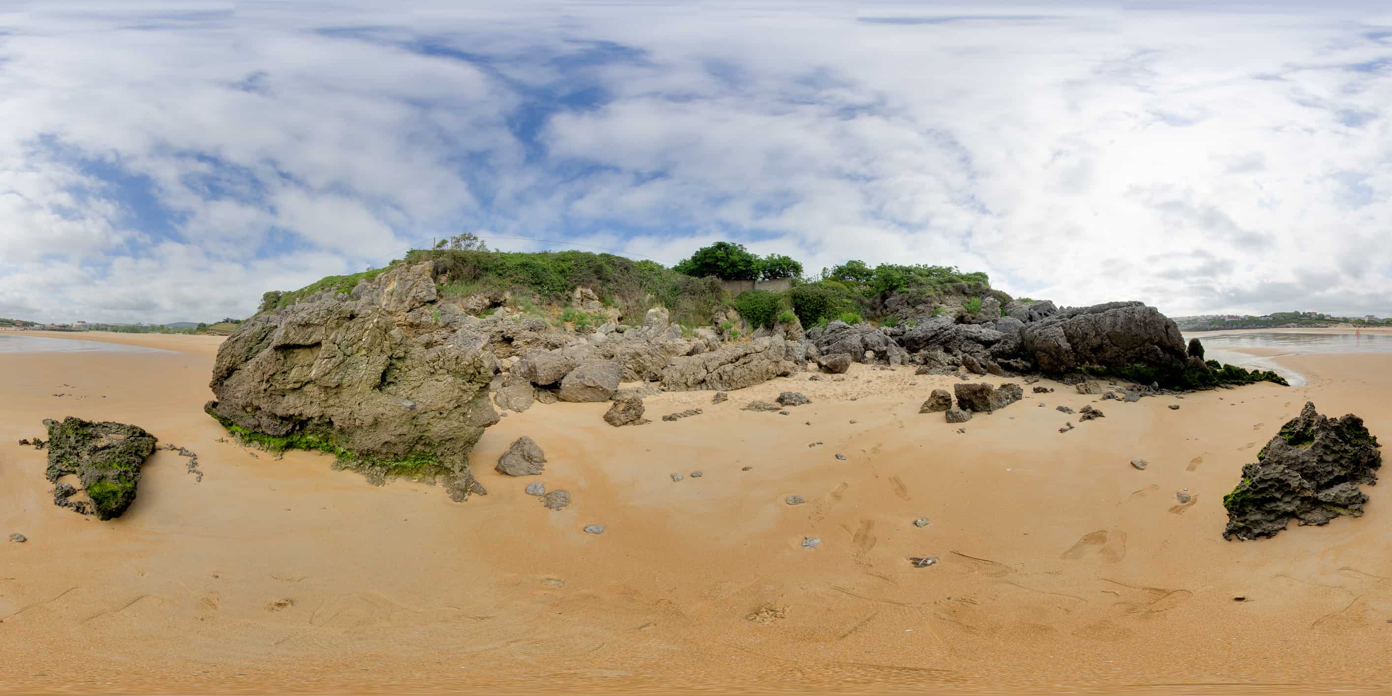 Protected dunes with coastal vegetation behind Playa de Ajo, sand in the foreground