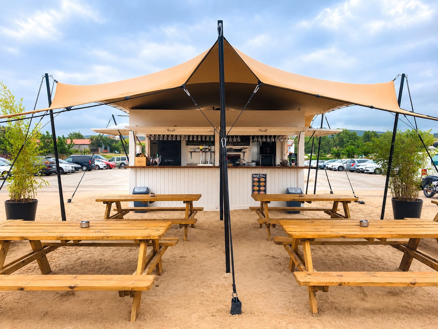 Seasonal beach bar and beach shower at Playa de Ajo, with sunshades in the background