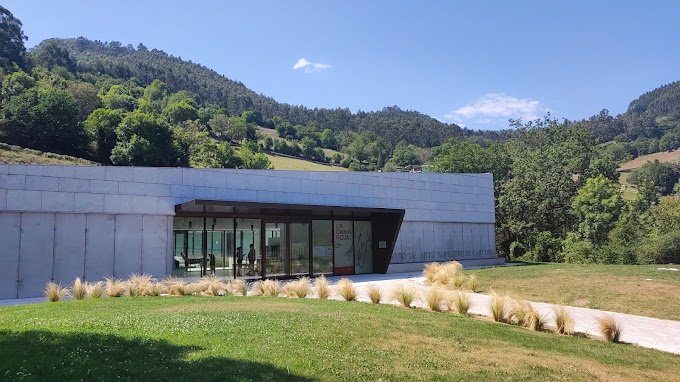 Eingang des Höhlenkunstzentrums Kantabriens in Puente Viesgo, mit der Berglandschaft im Hintergrund