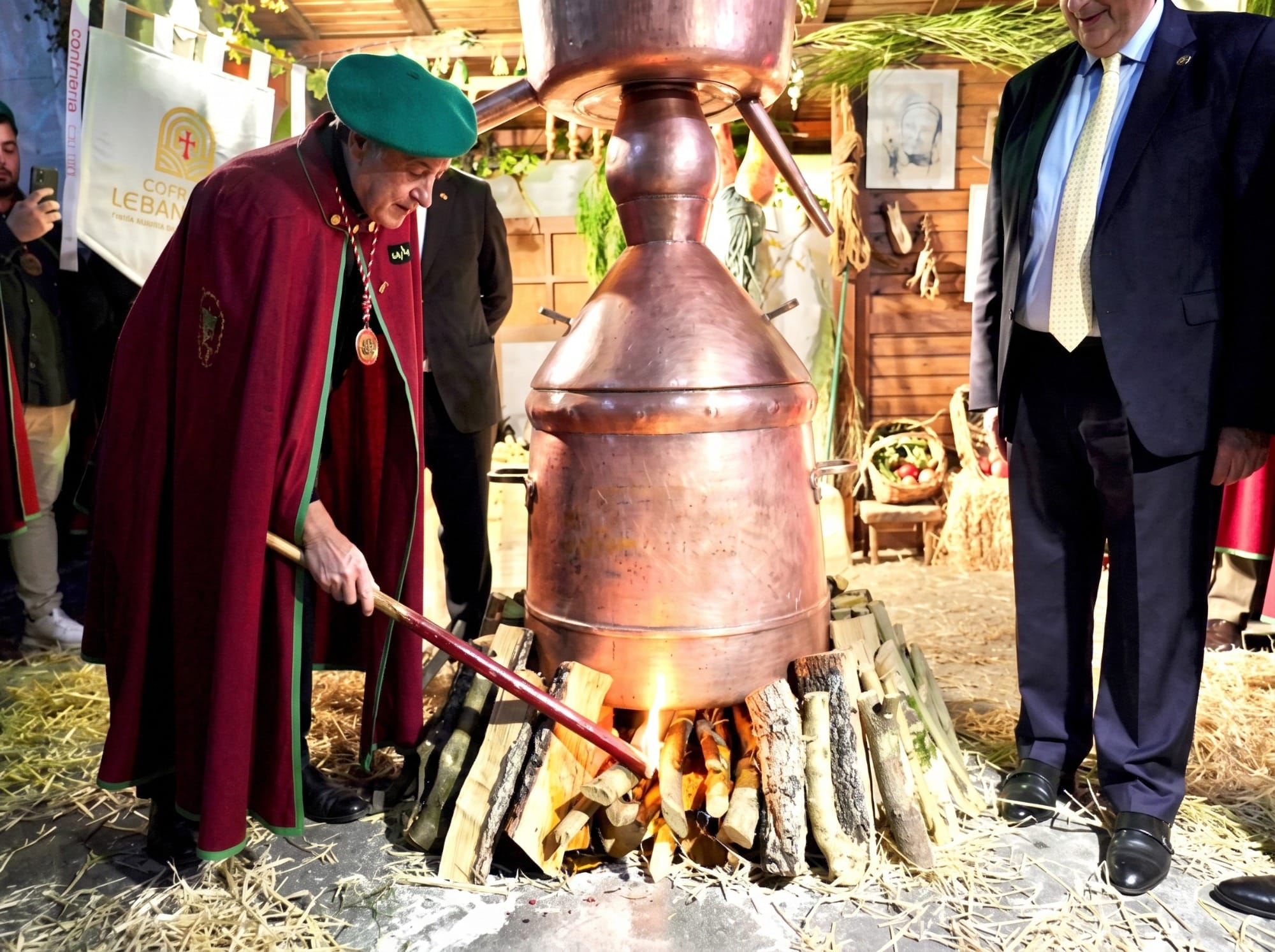 Alquitara de cobre encendida en una calle de Potes durante la Fiesta del Orujo, con público alrededor