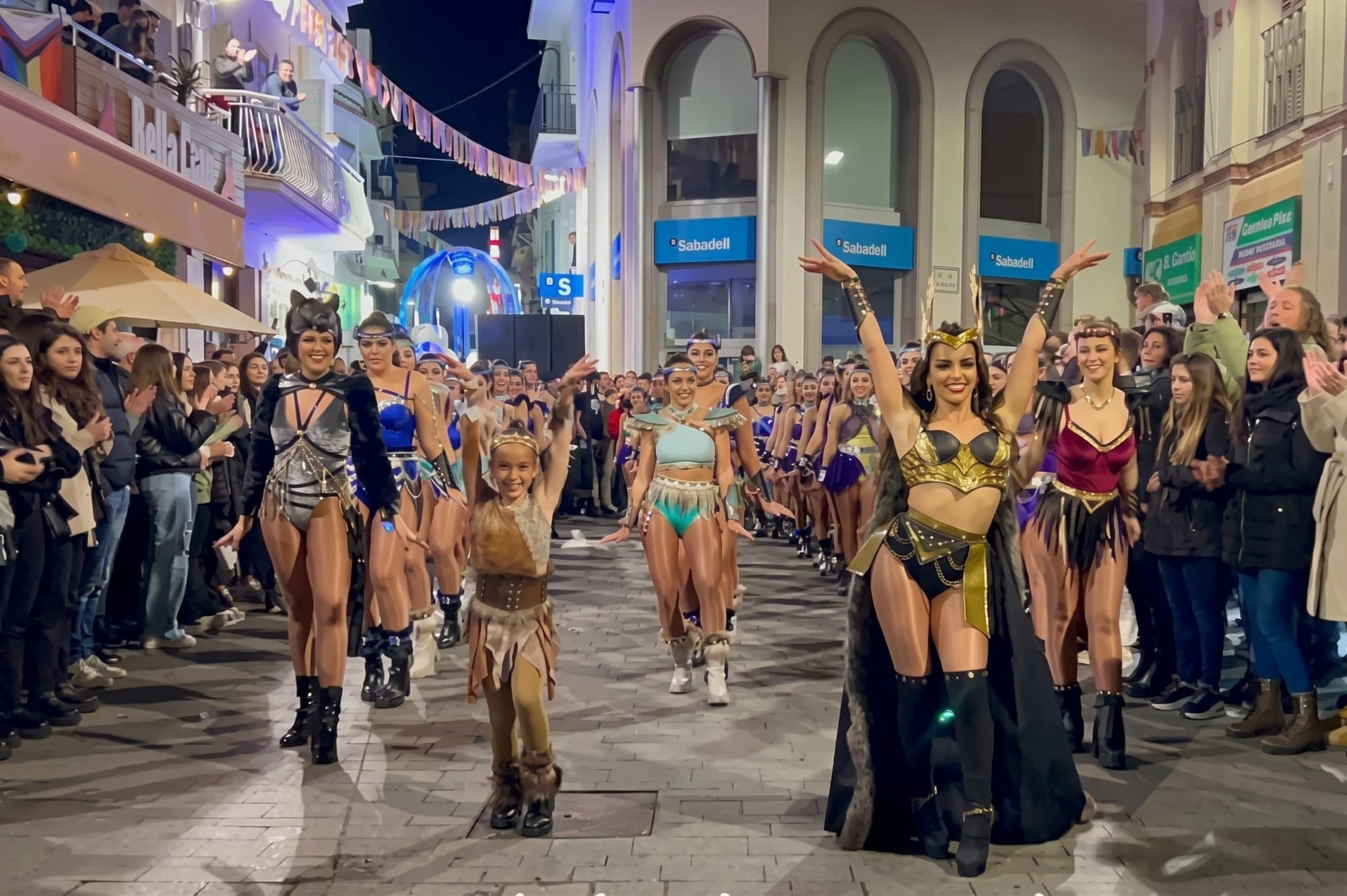 Calle del casco urbano de Santoña con ambiente festivo y gente disfrazada, plano medio