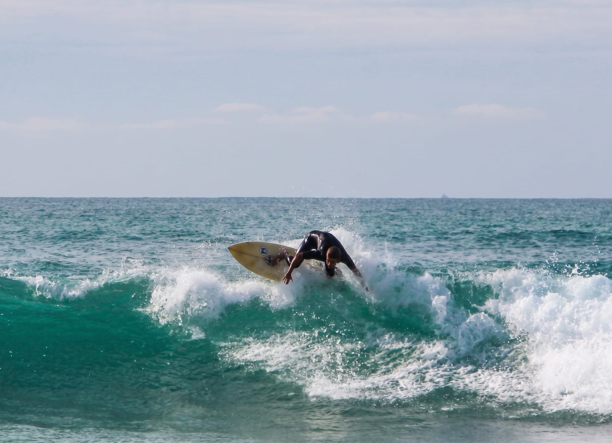 Surfista entrando al mar en Valdearenas con oleaje fuerte, vista lateral