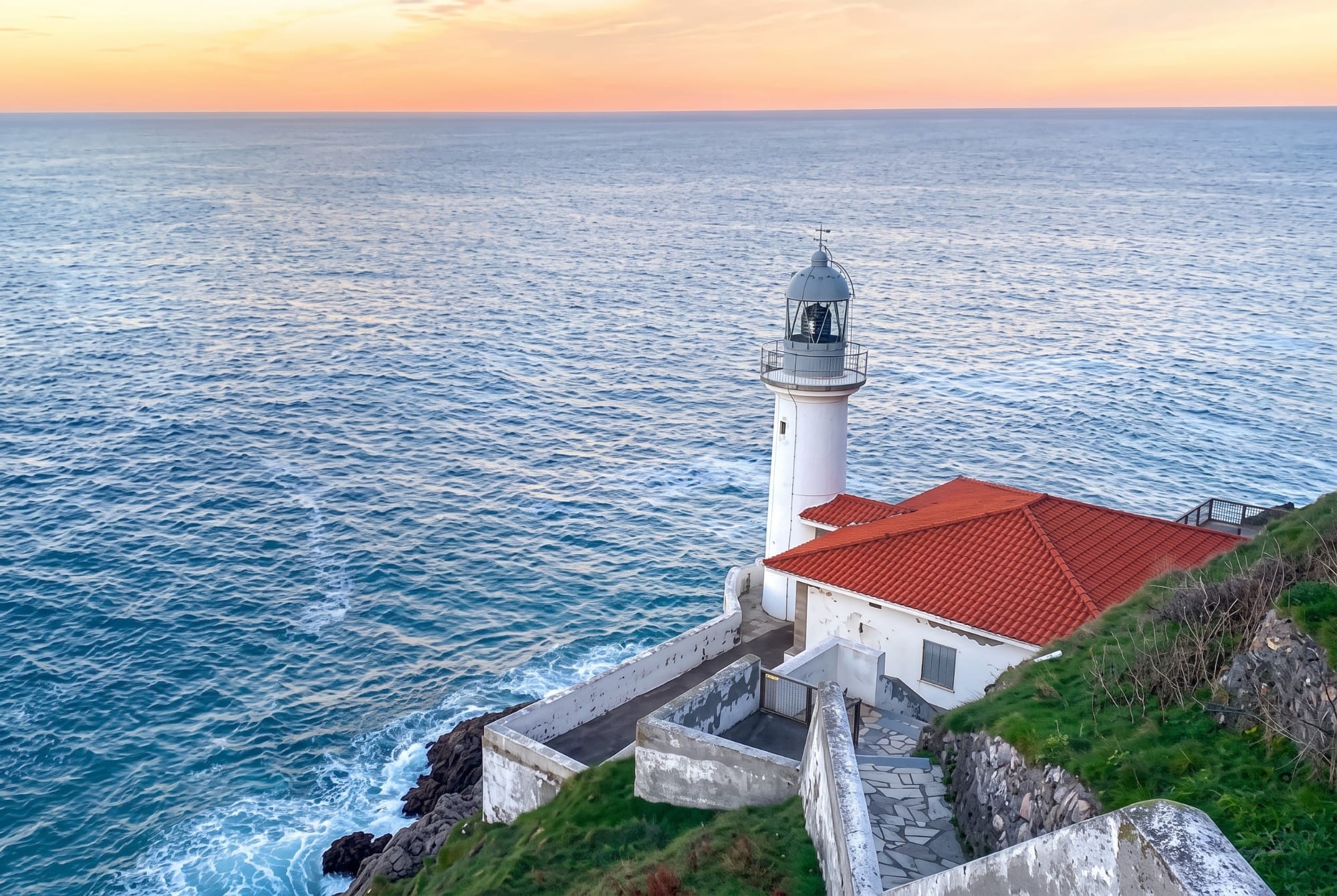 The old Punta de la Silla lighthouse, home of the visitor centre, with the cliffs in the background