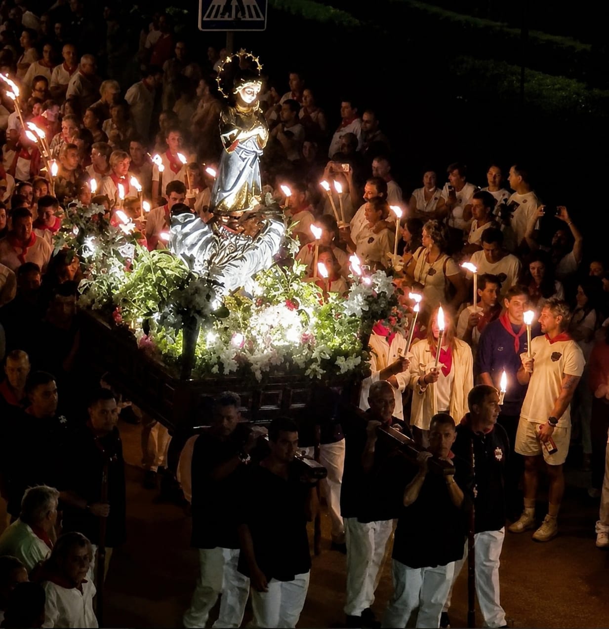 Procession aux flambeaux dans les rues d'Ampuero la nuit, avec les Pandereteras Virgen Niña de Ampuero et la Banda Municipal de Ramales