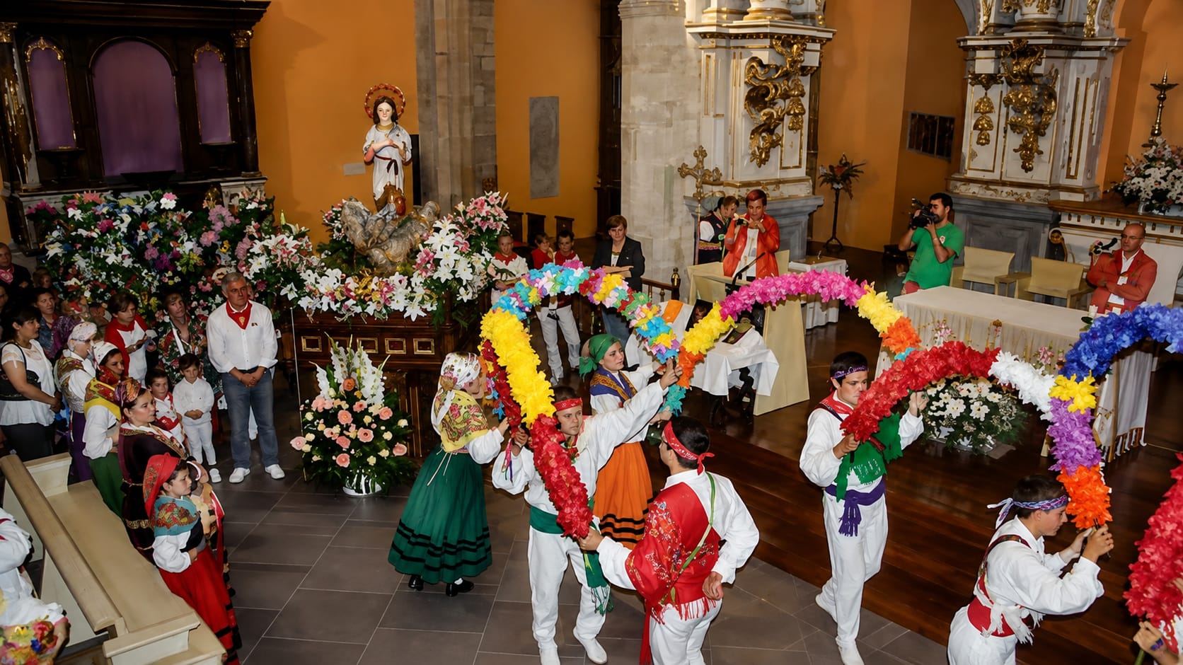 Offrande florale à la Vierge Niña devant l'église Santa María d'Ampuero, avec un groupe de danse folklorique cantabrique sur la Plaza Mayor