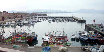 Dock at the Club Náutico de Santoña with pleasure boats moored, early morning light.