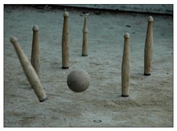 Exhibición de bolos cántabros durante una fiesta patronal, público alrededor de la bolera