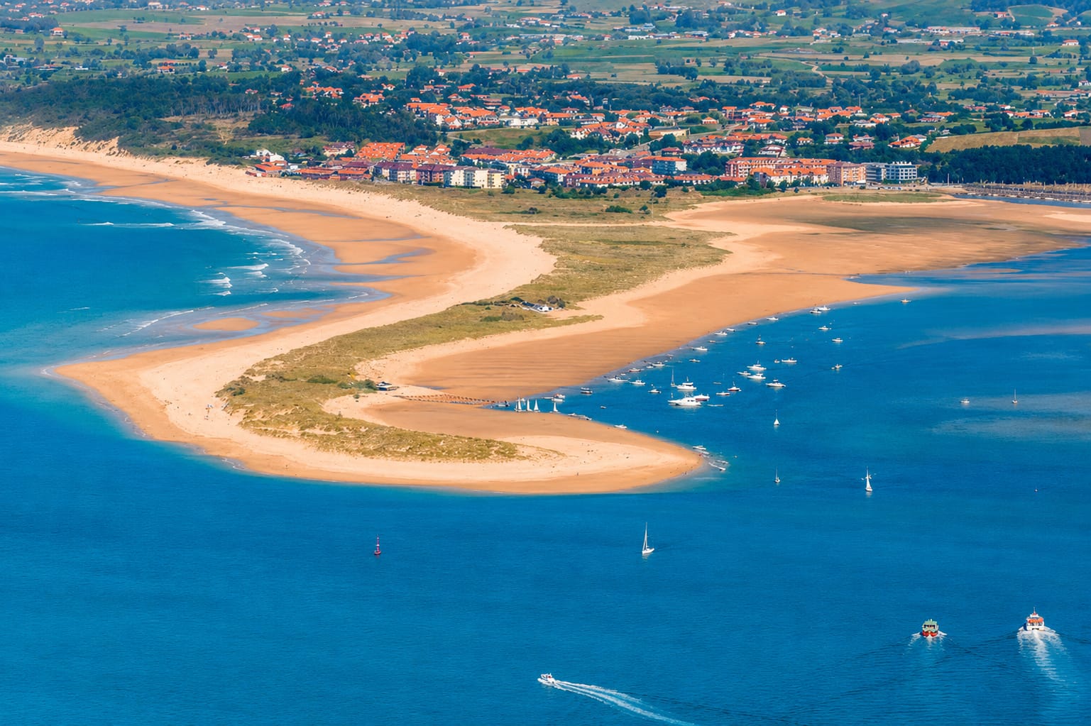 Aerial or shoreline view of Playa del Puntal in Somo, showing the sandbar between Santander Bay and the Cantabrian Sea