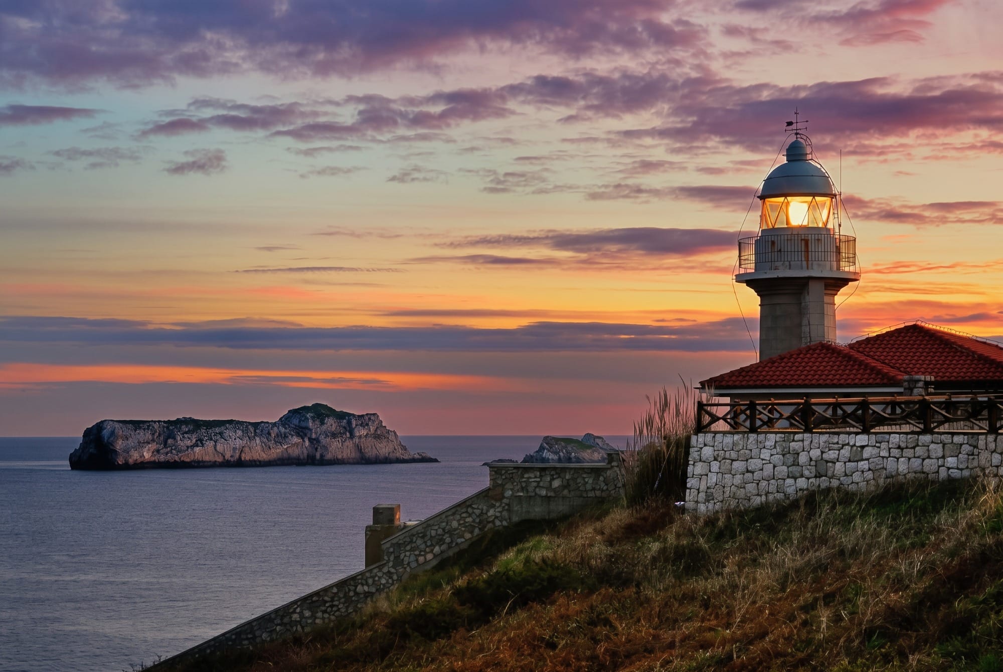 Punta del Torco de Afuera lighthouse in Suances in mid-morning light, with the El Torco building beside it