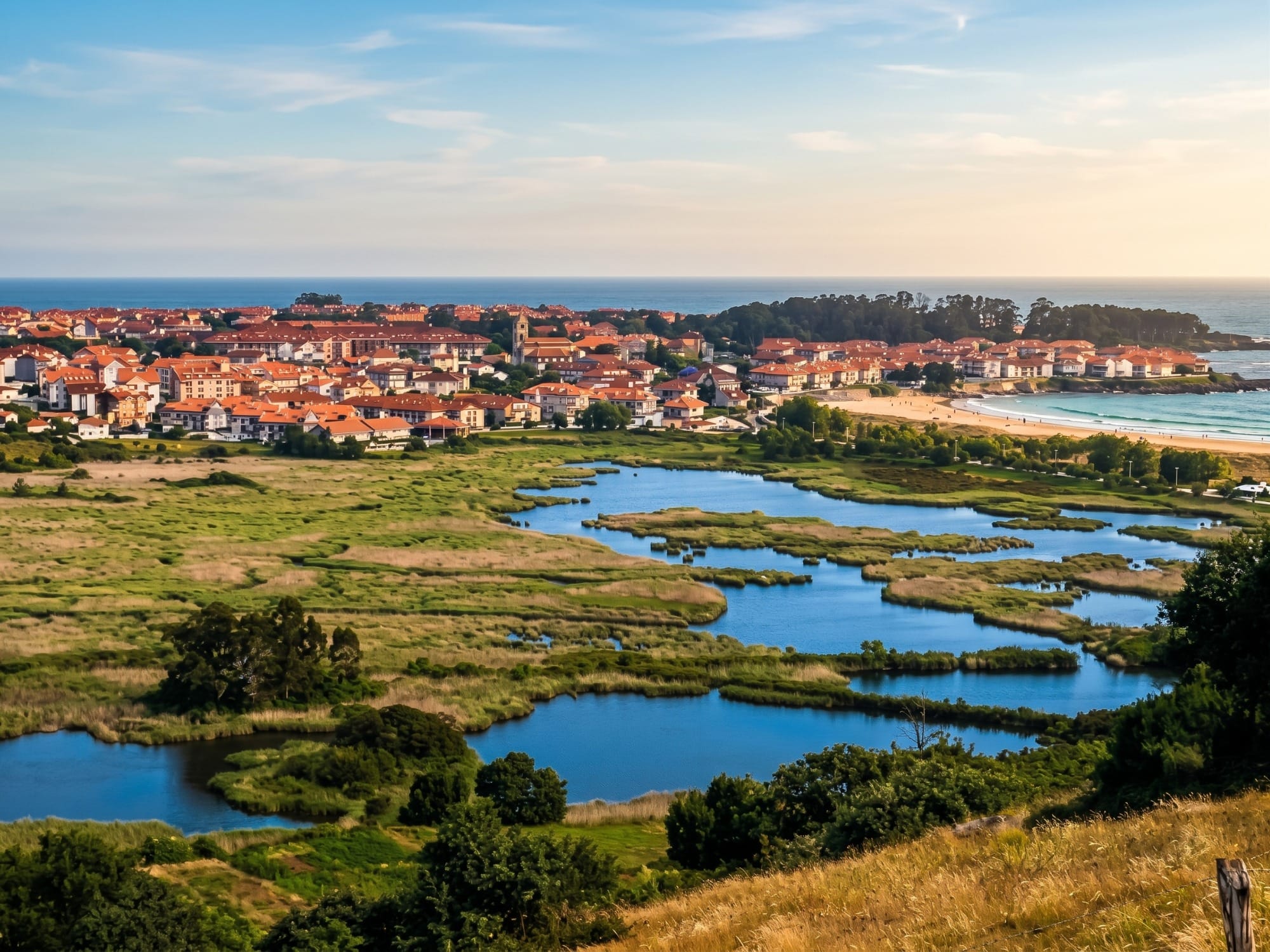 Gesamtansicht der Marsch von Joyel mit der Ría bei Flut und Vögeln im Hintergrund