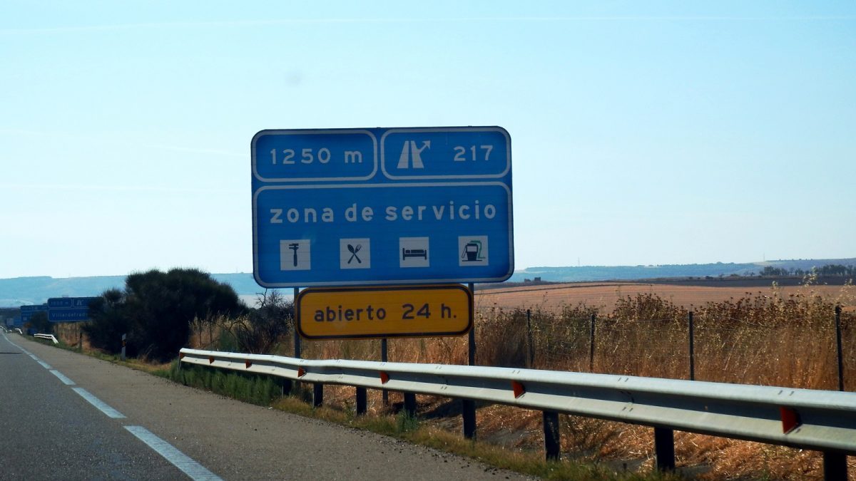 The N-634 road crossing the Trasmiera coast on the way to Bareyo, a petrol station sign in the background